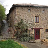 an old stone house with a red door and a red door at La Dame de Messignac in Ternand