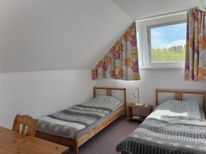 two beds in a room with a window at Siófoki nyaralóház in Siófok