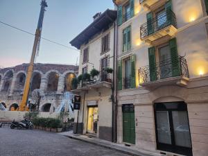 a building with green doors and balconies on a street at Residenza Wega - Luxury Apartments Verona in Verona