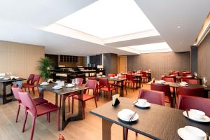 Un comedor con mesas y sillas rojas. en Qingshi Yunxi, en Guangzhou 12 fotos más