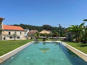 a swimming pool in a yard with a house at Paços de Douro - Chambre 1 Jardin & Lumière in Romariz