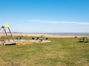 a playground in a field with the ocean in the background at Seaside Haven in Vadehavet - By Traum Ferienwohnungen in Bolilmark +20 photos
