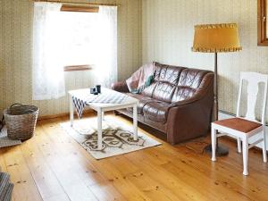 a living room with a couch and a table at 4 person holiday home in Vimmerby in Krogsfall
