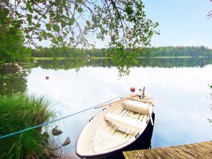 a boat tied to a dock on a lake at 4 person holiday home in Vimmerby in Krogsfall