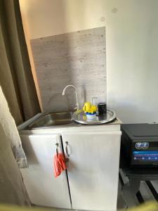 a kitchen counter with a sink and a stove at Mlimani city studio apartment in Dar es Salaam +4 photos