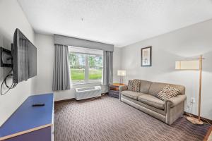 a living room with a couch and a tv at Independence Stay Long Term and Suites in Marinette