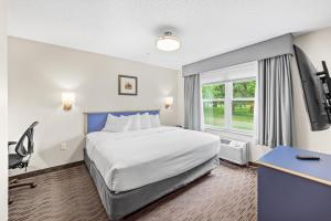 a hotel room with a bed and a window at Independence Stay Long Term and Suites in Marinette