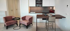 a kitchen with a wooden table and two bar chairs at Unique Seaview Studio - Marina Village in Radovići +8 photos
