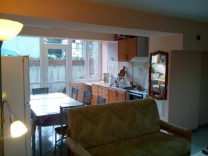 a living room with a couch and a table and a kitchen at Aleks Guest House in Samokov