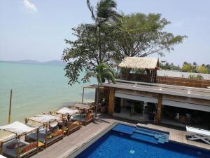 a hotel with a swimming pool next to the ocean at Tropical Serenity - Elegant 1 Bedroom with Pool in Ban Saiyuan (1)