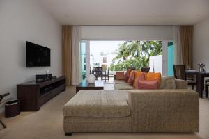 a living room with a couch and a television at Tropical Serenity - Elegant 1 Bedroom with Pool in Ban Saiyuan (1)