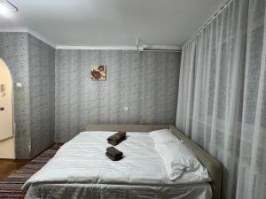 a bedroom with a bed with white sheets and curtains at Chișinău Airport Comfort in Chişinău