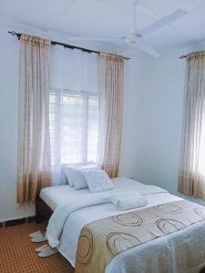 Ukunda AirportにあるDevkim staysの白いシーツと窓のあるベッドのある寝室