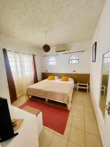 a bedroom with a bed and a red rug at Mont Choisy Lodge - Coco Apartment in Trou aux Biches