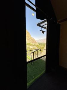 a room with a window with a view of a mountain at Gumaan Resort in Skardu +39 photos