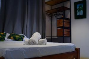a bedroom with a bed with towels on it at Vila Maré, vista panoramica do mar in Itacaré