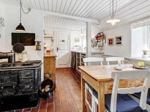 a kitchen with a wooden table and a stove at 4 person holiday home in Tønder in Tønder