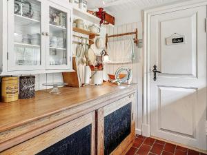 a kitchen with white cabinets and a wooden counter top at 4 person holiday home in Tønder in Tønder