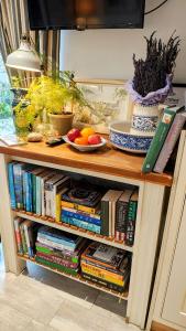 ein Bücherregal mit Büchern und Obst darauf in der Unterkunft Ropewalk Cottage - A Little Treasure By The Coast in Portaferry