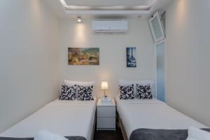 two beds in a small room with white walls at BeGuest Casa dos Poetas Oeiras Apartment in Oeiras
