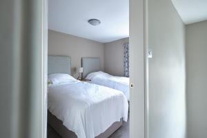 ein Schlafzimmer mit zwei Betten mit weißer Bettwäsche in der Unterkunft 1 Manor Cottage, Ainderby Steeple, DL7 9PX in Northallerton