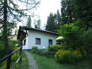 a white house with a fence next to a yard at Chalet Nassfeld nahe Skipisten in Sonnenalpe Nassfeld