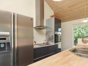 a kitchen with a stainless steel refrigerator and a sink at 8 person holiday home in Ålbæk-By Traum in Ålbæk