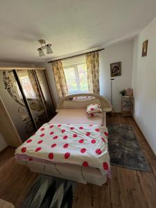 a bedroom with a bed with red flowers on it at Cabana Acasa la Delia in Gîrda de Sus