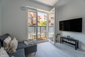 un salon avec un canapé et une télévision à écran plat dans l'établissement Pure Rental Premium Apartments Inżynierska - Free Parking & AC, à Wrocław