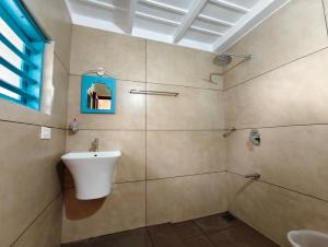 a bathroom with a sink and a shower at Aavi beach retreat, Nileshwar in Nīleshwar
