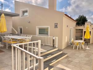 una casa con un patio con mesas y sillas en Zeca Holidays -Atalaia Fall Mezanine Ideal para trabalhar, en Lourinhã