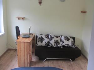 a room with a couch and a desk with a laptop at Holiday Home Stara Kamienica near Ski Slopes in Stara Kamienica +17 photos