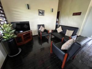 a living room with couches and a flat screen tv at Vale Kau in Nadi