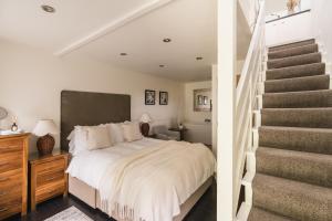 una camera da letto con un letto grande e una scala di Elterwater Cottage a Windermere