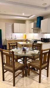 a kitchen with a glass table and chairs in it at Modern 1BR Apartment Bahria Heights 1 in Rawalpindi