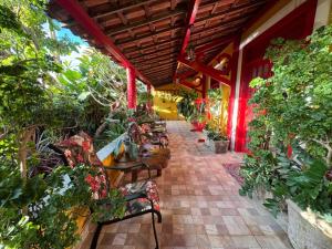 an outdoor patio with chairs and tables and plants at Pousada Leão in Maceió