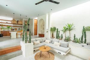 a living room with a white couch and a table at Your Romantic Mediterranean Villa in Canggu in Dalung
