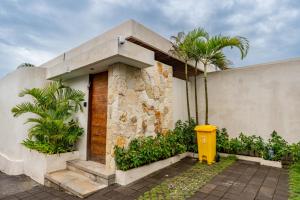 a house with a yellow trash can in front of it at Your Romantic Mediterranean Villa in Canggu in Dalung