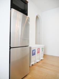 a kitchen with a refrigerator in a room at 9Stay辻堂 in Chigasaki +91 photos