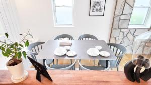 a dining room table with chairs and a table and a plant at 9Stay辻堂 in Chigasaki