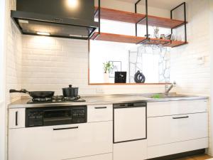 a kitchen with white cabinets and a stove at 9Stay辻堂 in Chigasaki