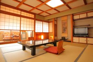 a large room with a table and a television at Ryokan Seiryu (Specialised in Hida beef) in Takayama