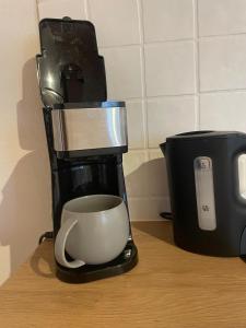 a coffee maker and a coffee cup on a counter at Wohnung im Landhaus - mit Terasse & Bachlauf in Trösel