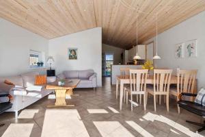 a living room with a couch and a table at Cosy Cottage On North Funen Near Beach in Otterup +2 photos