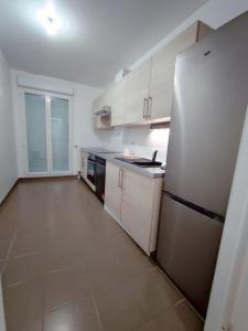 a kitchen with white cabinets and a stainless steel refrigerator at Charming 3 rooms with parking in Rueil-Malmaison