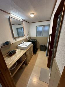 a bathroom with a sink and a mirror at Cottage Kirihata in Tanabe