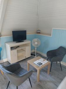 a living room with two chairs and a tv and a table at Studio 6 proche du port in Cancale