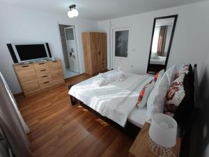 a bedroom with a bed and a flat screen tv at Casa Ioana Întorsura Buzăului in Brădet