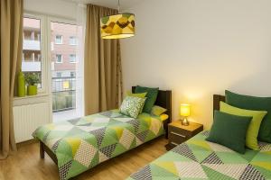 a bedroom with two beds and a window at TK Apartments Spiżowa in Wrocław