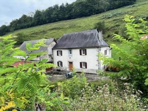 a white house with a black roof on a hill at Maison Hastoy in Lacarry-Arhan-Charritte-de-Haut